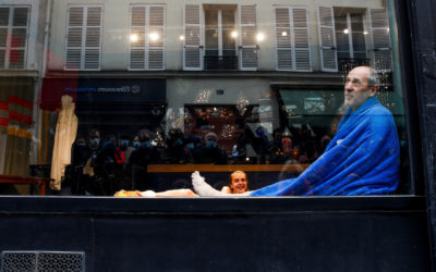 Actores realizan presentación en vitrina de un negocio en Francia